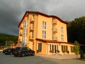 a yellow building with cars parked in front of it at Metropol in Baile Felix