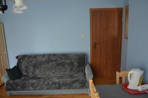 un sofá en una sala de estar con mesa en Pokoje Gościnne Szuber, en Iwonicz-Zdrój