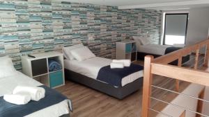 a bedroom with two beds and a brick wall at Casa dos Codessos in Ribeira de Pena