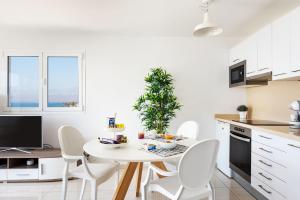 una cucina bianca con tavolo e sedie bianchi di ESTELAI by Buenavilla a Puerto del Carmen