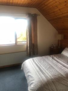 um quarto com uma cama e uma grande janela em 12 Tullybay Drumcrow east with WIFI em Enniskillen