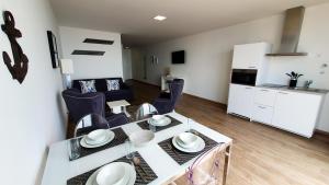 
a living room with a table and chairs at Miramar Hotel Spa & Apartments in Nazaré
