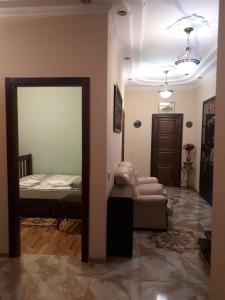 een woonkamer met een bed en een spiegel bij Guest House Ralsh in Tbilisi City