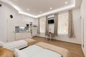 a living room with white furniture and a kitchen at Budapest Holidays Downtown in Budapest