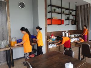 un grupo de personas en una cocina preparando comida en Baan Bangkok 97 Hotel en Pathum Thani