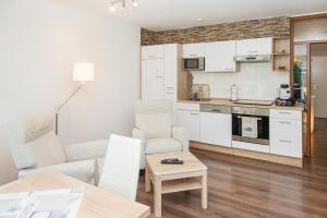 a kitchen and living room with white cabinets and a table at Rhinkieker Rees in Rees