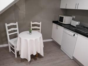uma pequena cozinha com uma mesa e um micro-ondas em Frentomar em Albufeira