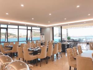 a restaurant with tables and chairs and a view of the water at Vincent Halong Hotel in Ha Long