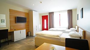 a hotel room with two beds and a desk at Nava Motel & Storage in Wiener Neustadt