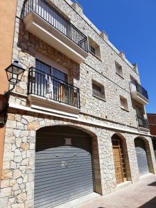 a building with a garage door and a balcony at CAL SOLÉ in Ulldemolins