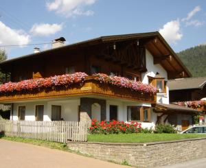 a house with flowers on the top of it at Apartments Pötscher in Matrei in Osttirol