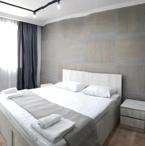 a bedroom with a large white bed with two pillows at ART HOUSE 33 in Kutaisi