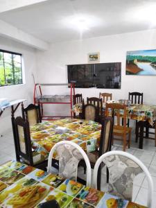 a dining room with tables and chairs and a room with a bed at Pousada dos Ventos in Pôrto de Pedras
