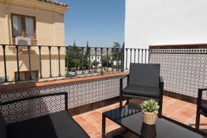 a balcony with two chairs and a table with a plant at Apartamento Centro La Paz by CasaTuristica in Ronda