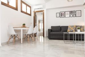 a living room with a table and white chairs at Apartamento Centro La Paz by CasaTuristica in Ronda