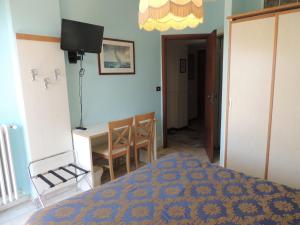 1 dormitorio con 1 cama, mesa y sillas en Hotel Rosalia, en Bordighera