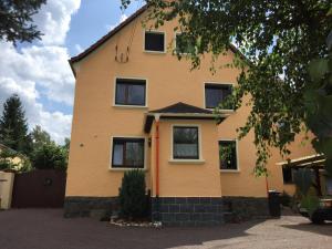 a yellow house with black windows at Ferienwohnung Schulze in Freital