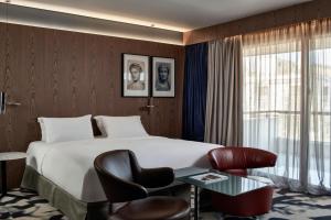 a hotel room with a large bed and a large window at AthensWas Design Hotel in Athens