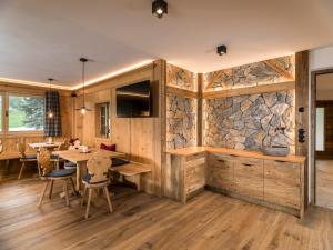 a room with a stone wall and a table and chairs at Waidacherhof Apartments in Braies