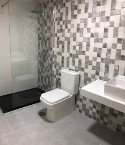 a bathroom with a white toilet and a sink at New Click & Room in Torremolinos