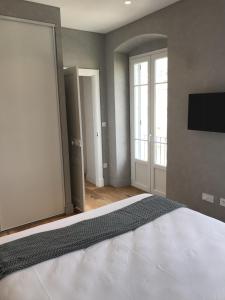 une chambre avec un lit et une télévision au mur dans l'établissement Les Terrasses de Padoue, à Corte