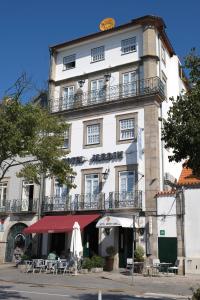 a tall white building with tables and chairs in front of it at Hotel Jardim Viana do Castelo in Viana do Castelo