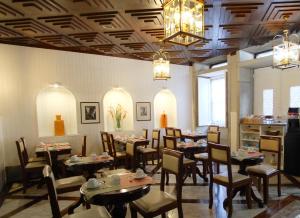 a dining room with tables and chairs and a chandelier at Hotel Jardim Viana do Castelo in Viana do Castelo