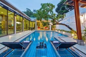 Nong Prue的住宿－Hi At Home Villa 4，一个带两把椅子的游泳池以及一座房子