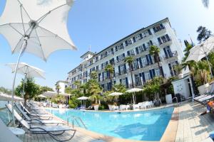 a hotel with a swimming pool with chairs and umbrellas at Hotel Lido Seegarten in Lugano