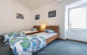 sypialnia z dwoma łóżkami i oknem w obiekcie House Hermes w mieście Pavicini