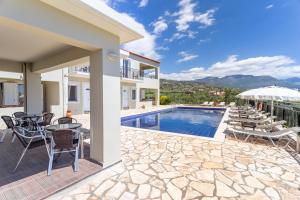 a villa with a swimming pool and a patio at Hotel Aphrodite in Stoupa