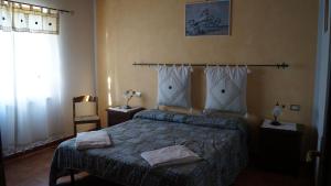 1 dormitorio con 1 cama, 2 lámparas y ventana en Agriturismo Poggio San Pietro, en Pitigliano