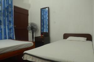 - une chambre avec 2 lits jumeaux et un ventilateur dans l'établissement Sihagiri Homestay, à Dambulla