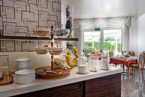 a kitchen with a counter with bowls and plates at Hotel Augusta in Malcesine