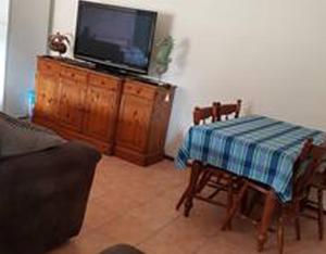 a living room with a table and a flat screen tv at Theme Park Getaway in Gold Coast