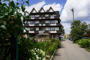 una casa alta con techo en una calle en Ośrodek Wypoczynku Dziubas Jan - 500 m od Stacji Narciarskiej Kaniówka, en Białka Tatrzanska