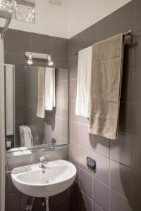 y baño con lavabo, espejo y toallas. en B&B Villa Adriana, en Tívoli