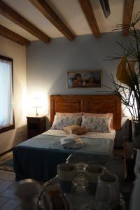 a bedroom with a bed with a wooden head board at LA BRIGATA APARTMENTS Suite Room in Cavallino-Treporti