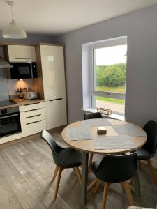 a kitchen and dining room with a table and chairs at 23 C Allan Gardens in Dornoch