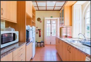a kitchen with a sink and a microwave at Beach Park Guesthouse in Vila do Conde