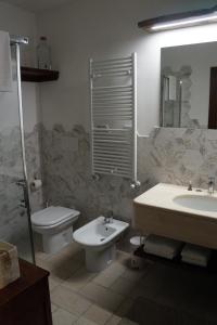 W łazience znajduje się umywalka, toaleta i umywalka. w obiekcie LA BRIGATA APARTMENTS Suite Room w Cavallino-Treporti