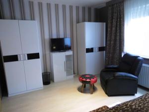 uma sala de estar com uma cadeira preta e uma televisão em Dein Zuhause auf Zeit em Heringen