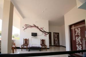 a living room with chairs and a tv on the wall at Tadoba Homestay Cottage in Chandrapur