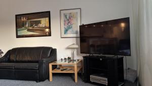 a living room with a couch and a flat screen tv at Goski & Gobike Winterberg 4K Netflix free in Winterberg