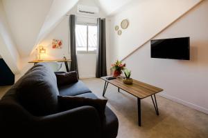 - un salon avec un canapé et une table dans l'établissement Appartements Le Bleu des Roches Noires, à Saint-Gilles les Bains