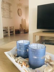 吉奧馬恩德勒德的住宿－Vadszőlő Apartmanház Gyomaendrőd，两个蓝色的杯子坐在桌子上的盘子上