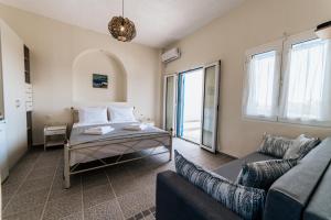 een woonkamer met een bed en een bank bij Cyclades Luxury Studios in Nea Potidaea