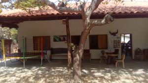 dom ze stołem i drzewem przed nim w obiekcie Pouso Divino dos Pireneus w mieście Pirenópolis