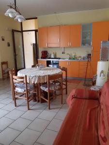 uma cozinha com armários laranja e uma mesa e cadeiras em Il Nido Degli Angeli em Calatabiano