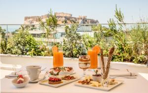 a table with food and a glass of wine at Electra Hotel Athens in Athens